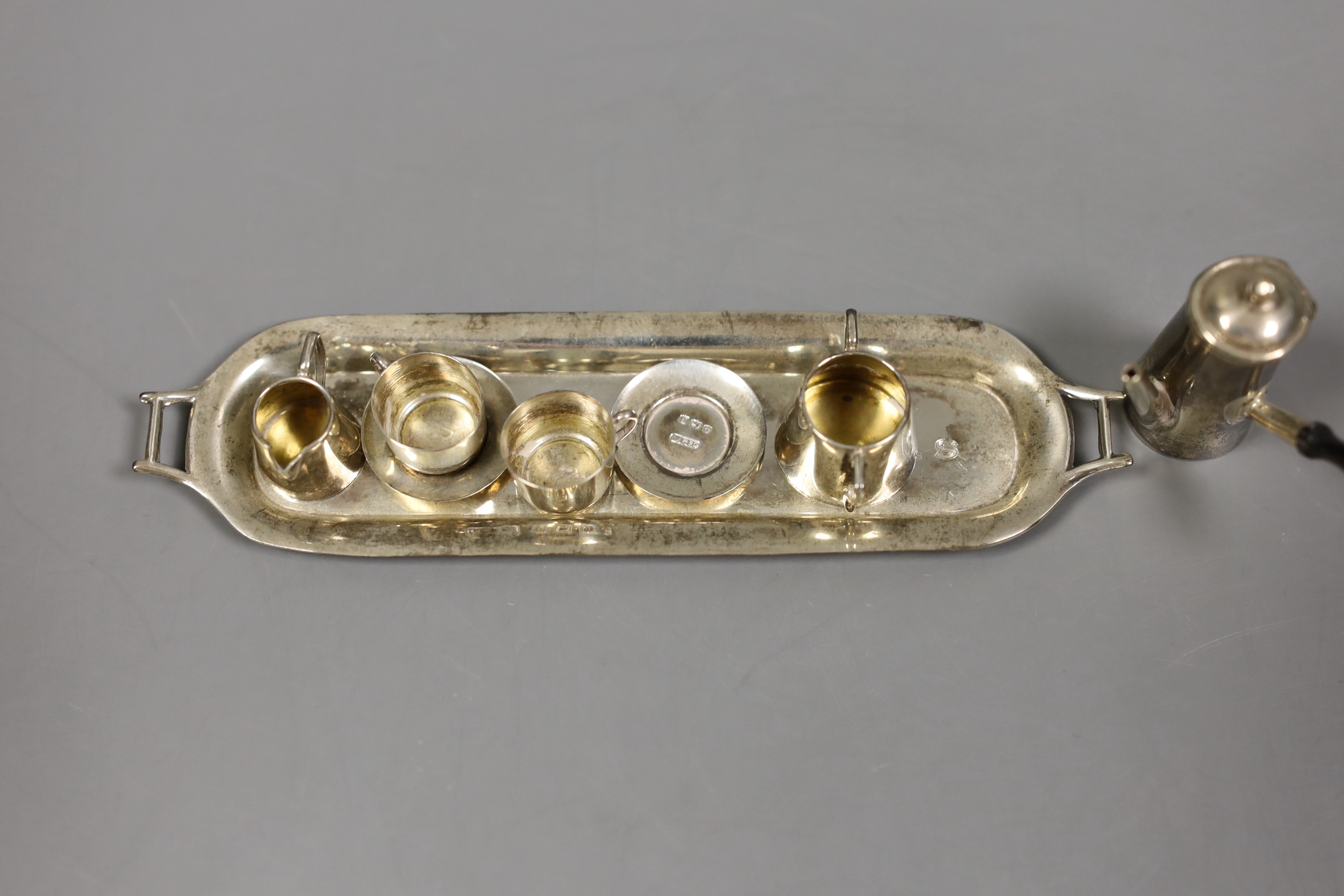 A George V silver miniature seven piece tea service on two handled tray, Saunders & Shepherd, Birmingham, 1913/4, tray 13.8cm.